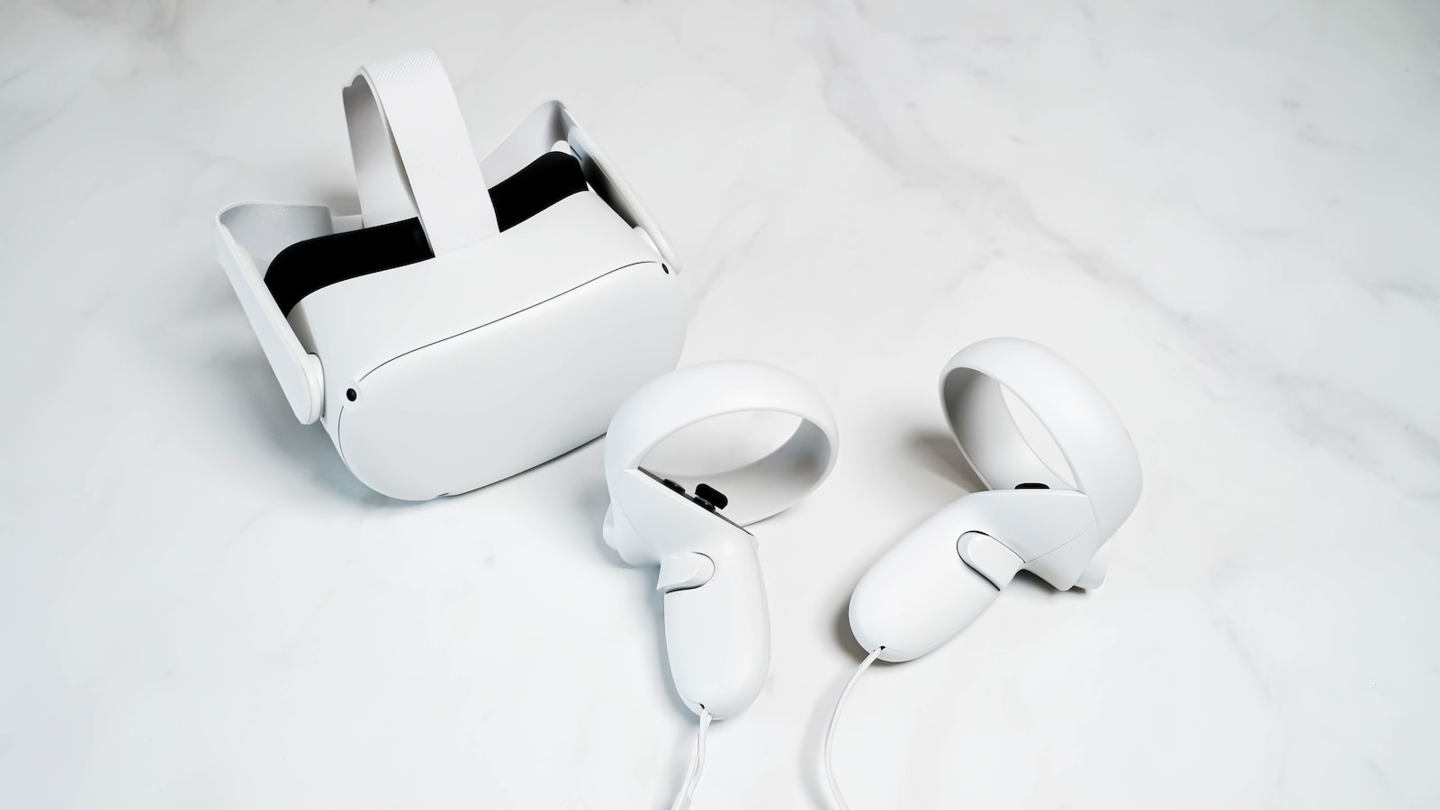 a pair of white vr headsets and controllers